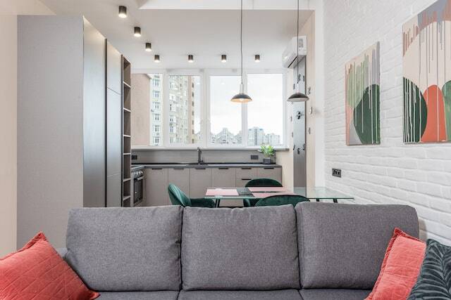 apartment living room interior with a grey couch and orange accent pillows